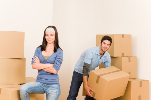Professional movers carrying boxes through a Leyton property entrance